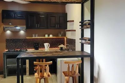 a kitchen with a counter and some wooden stools at Local secret apartament Blue Mountain in Quepos in Quepos