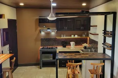 a kitchen with brown cabinets and a counter top at Local secret apartament Blue Mountain in Quepos in Quepos