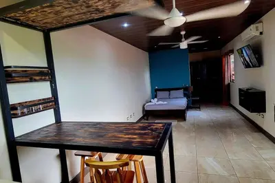 a living room with a table and a bed at Local secret apartament Blue Mountain in Quepos in Quepos