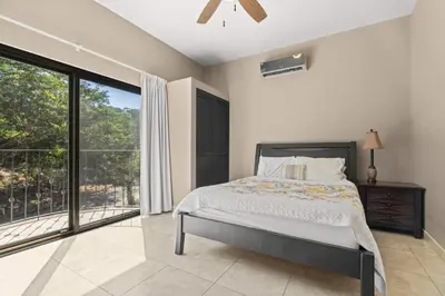 a bedroom with a bed and a large window at Casa Paulina in Playa Conchal