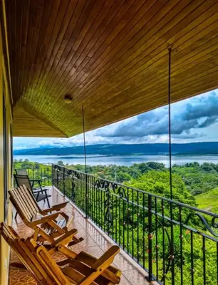 a balcony with chairs and a view of the forest at Villa Esperanza El Castillo in Fortuna