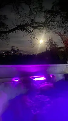 a pool with purple lights in the water at night at Casa Marigold in Coyol