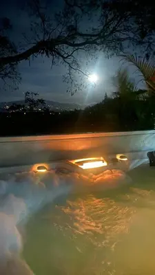 a pool with a light in the water at night at Casa Marigold in Coyol