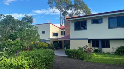 a white house with a driveway in front of it at Casa Marigold in Coyol