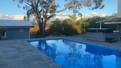 a swimming pool with a grill next to a house at Casa Marigold in Coyol