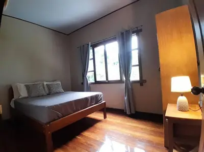 a bedroom with a bed and a window at Riverside Oasis Cabin with A C in Guápiles