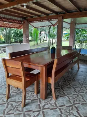 a wooden table and two benches in a patio at Riverside Oasis Cabin with A C in Guápiles