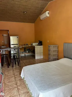 a bedroom with a bed and a table and chairs at Cabinas Paraíso in Dominical