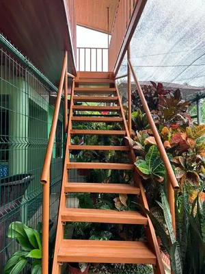 a wooden staircase in a building with plants at Cabinas Paraíso in Dominical