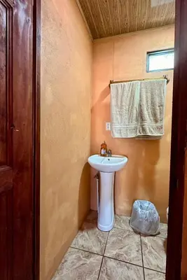 a bathroom with a white sink and a towel at Cabinas Paraíso in Dominical