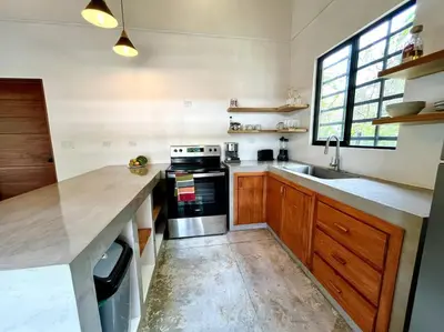a kitchen with a counter and a stove and a sink at 3 Bdr Villa With Pool , Near beach, Fast Wifi in Veintisiete de Abril