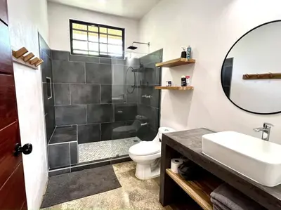 a bathroom with a shower and a toilet and a sink at 3 Bdr Villa With Pool , Near beach, Fast Wifi in Veintisiete de Abril
