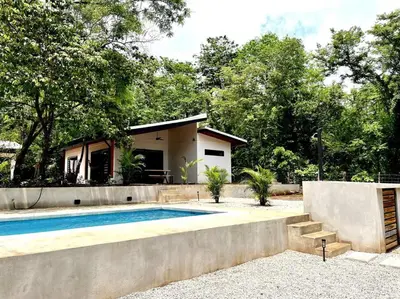 a house with a swimming pool in front of a house at 3 Bdr Villa With Pool , Near beach, Fast Wifi in Veintisiete de Abril