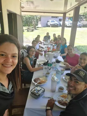 a group of people sitting at a table eating food at Haciendo Amigos en el Canasto in San Isidro