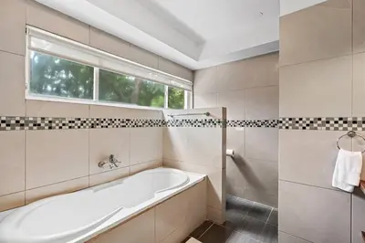 a white bathroom with a tub and a window at BLA1 3 Bedroom Condo with Direct Beach Access in Tamarindo