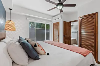 a bedroom with a bed with pillows and a ceiling fan at BLA1 3 Bedroom Condo with Direct Beach Access in Tamarindo
