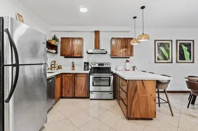 a kitchen with a stainless steel refrigerator and wooden cabinets at BLA1 3 Bedroom Condo with Direct Beach Access in Tamarindo
