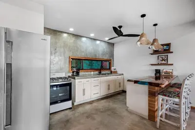 a kitchen with white cabinets and a stove top oven at Casa Indy 3bdrm Home with Pool in Town Centre in Tamarindo
