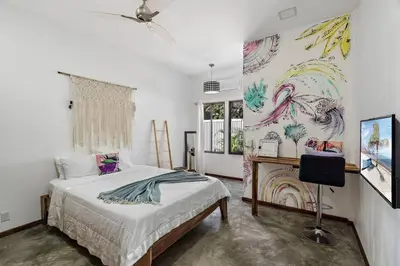 a bedroom with a bed and a painting on the wall at Casa Indy 3bdrm Home with Pool in Town Centre in Tamarindo