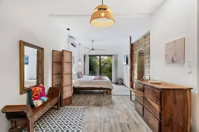 a bedroom with a bed and a dresser and a mirror at Casa Indy 3bdrm Home with Pool in Town Centre in Tamarindo