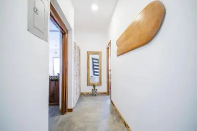 a hallway with a door and a mirror on the wall at Casa Indy 3bdrm Home with Pool in Town Centre in Tamarindo