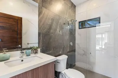 a bathroom with a shower and a toilet and a sink at CU15 New Modern Home with Casitas and Private Pool in Tamarindo