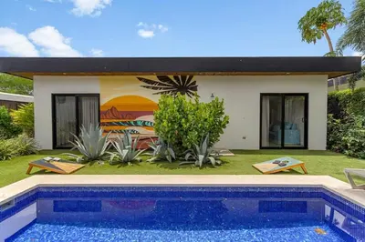 a villa with a swimming pool in front of a house at CU15 New Modern Home with Casitas and Private Pool in Tamarindo