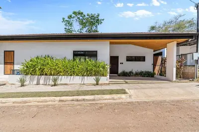 a white house with plants in front of it at CU15 New Modern Home with Casitas and Private Pool in Tamarindo