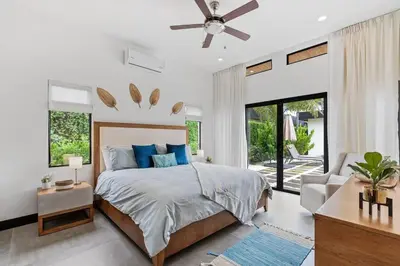 a bedroom with a bed and a ceiling fan at CU20 Modern Beach Home w Guest House & Pvt Pool in Villarreal