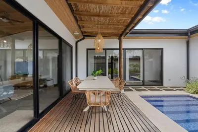 a dining room with a table and chairs on a deck at CU20 Modern Beach Home w Guest House & Pvt Pool in Villarreal