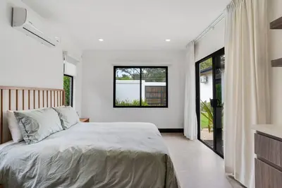 a bedroom with a large bed and some windows at CU20 Modern Beach Home w Guest House & Pvt Pool in Villarreal