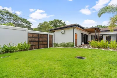 a house with a green lawn in front of it at CU20 Modern Beach Home w Guest House & Pvt Pool in Villarreal