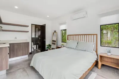 a bedroom with a large bed and a kitchen at CU20 Modern Beach Home w Guest House & Pvt Pool in Villarreal