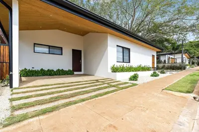 a white house with a driveway at CU27 New Construction 3bdrm Home with Prv Pool in Tamarindo