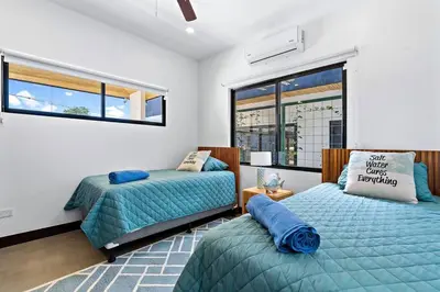a bedroom with two beds and a window at CU27 New Construction 3bdrm Home with Prv Pool in Tamarindo
