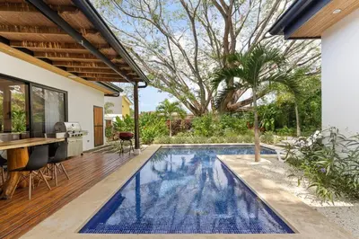 a swimming pool in a backyard with a house at CU28 New 3 Bdrm Home w Pool and Guanacaste Tree in Tamarindo