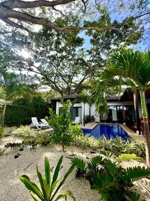 a house with a swimming pool in the yard at CU28 New 3 Bdrm Home w Pool and Guanacaste Tree in Tamarindo