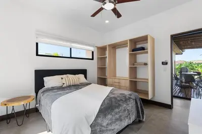 a bedroom with a bed and a ceiling fan at CU28 New 3 Bdrm Home w Pool and Guanacaste Tree in Tamarindo