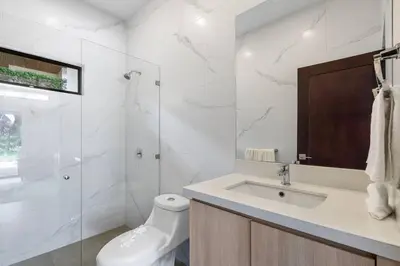 a white bathroom with a sink and a shower at CU28 New 3 Bdrm Home w Pool and Guanacaste Tree in Tamarindo