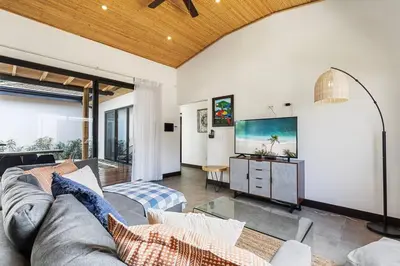 a living room with a couch and a tv at CU28 New 3 Bdrm Home w Pool and Guanacaste Tree in Tamarindo