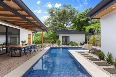a swimming pool in a backyard with a table and chairs at CU7 Beach Home Oasis with Private Pool and Guest House in Barco Quebrado