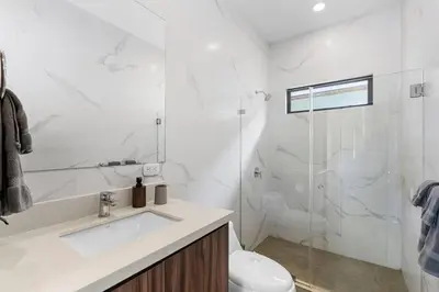 a white bathroom with a sink and a shower at CU7 Beach Home Oasis with Private Pool and Guest House in Barco Quebrado