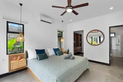 a bedroom with a bed and a ceiling fan at CU7 Beach Home Oasis with Private Pool and Guest House in Barco Quebrado
