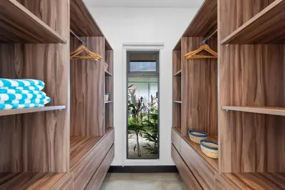 a walk in closet with wooden shelves and a door at CU7 Beach Home Oasis with Private Pool and Guest House in Barco Quebrado