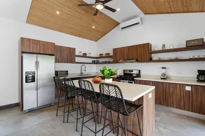 a kitchen with a center island with bar stools at CU7 Beach Home Oasis with Private Pool and Guest House in Barco Quebrado