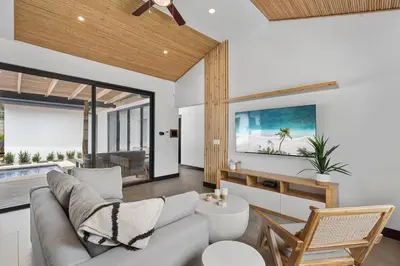 a living room with a couch and a tv at CU7 Beach Home Oasis with Private Pool and Guest House in Barco Quebrado