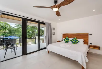 a bedroom with a bed and a ceiling fan at Modern New Villa in Playa Potrero Close to Beach in Potrero
