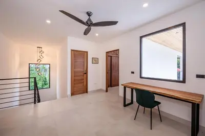 a dining room with a table and a ceiling fan at Modern New Villa in Playa Potrero Close to Beach in Potrero