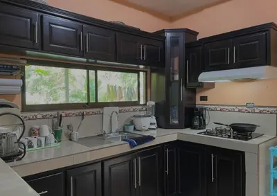 a kitchen with black cabinets and a sink and a window at Haciendo Amigos en El Canasto in San Isidro