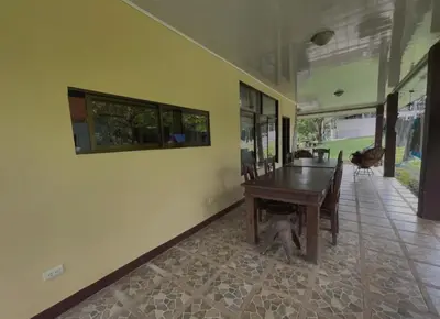 a dining room with a table and a dog under it at Haciendo Amigos en El Canasto in San Isidro